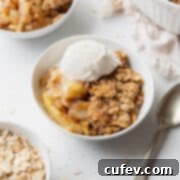 Comforting Gluten-Free Apple Crumble 5 A bowl of gluten free apple crisp with a scoop of vanilla ice cream on top.