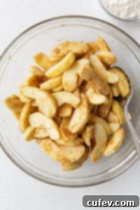 Comforting Gluten-Free Apple Crumble 6 Sliced apples tossed with spices in a glass bowl.