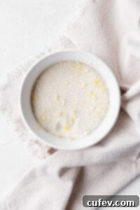 A white dish on a linen with lemon sugar inside.