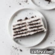 Velvet Chill Cake 4 A single slice of creamy no-bake icebox cake on a white plate, beautifully topped with crushed Oreo crumbs and ready to be enjoyed.