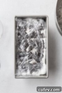 Velvet Chill Cake 8 The assembled icebox cake, neatly wrapped in plastic wrap and ready to be placed in the refrigerator for chilling, ensuring it sets properly.