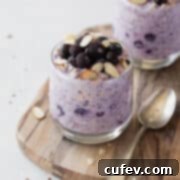 Wholesome Blueberry Overnight Oats 4 Blueberry overnight oats in a glass topped with frozen blueberries and sliced almonds.
