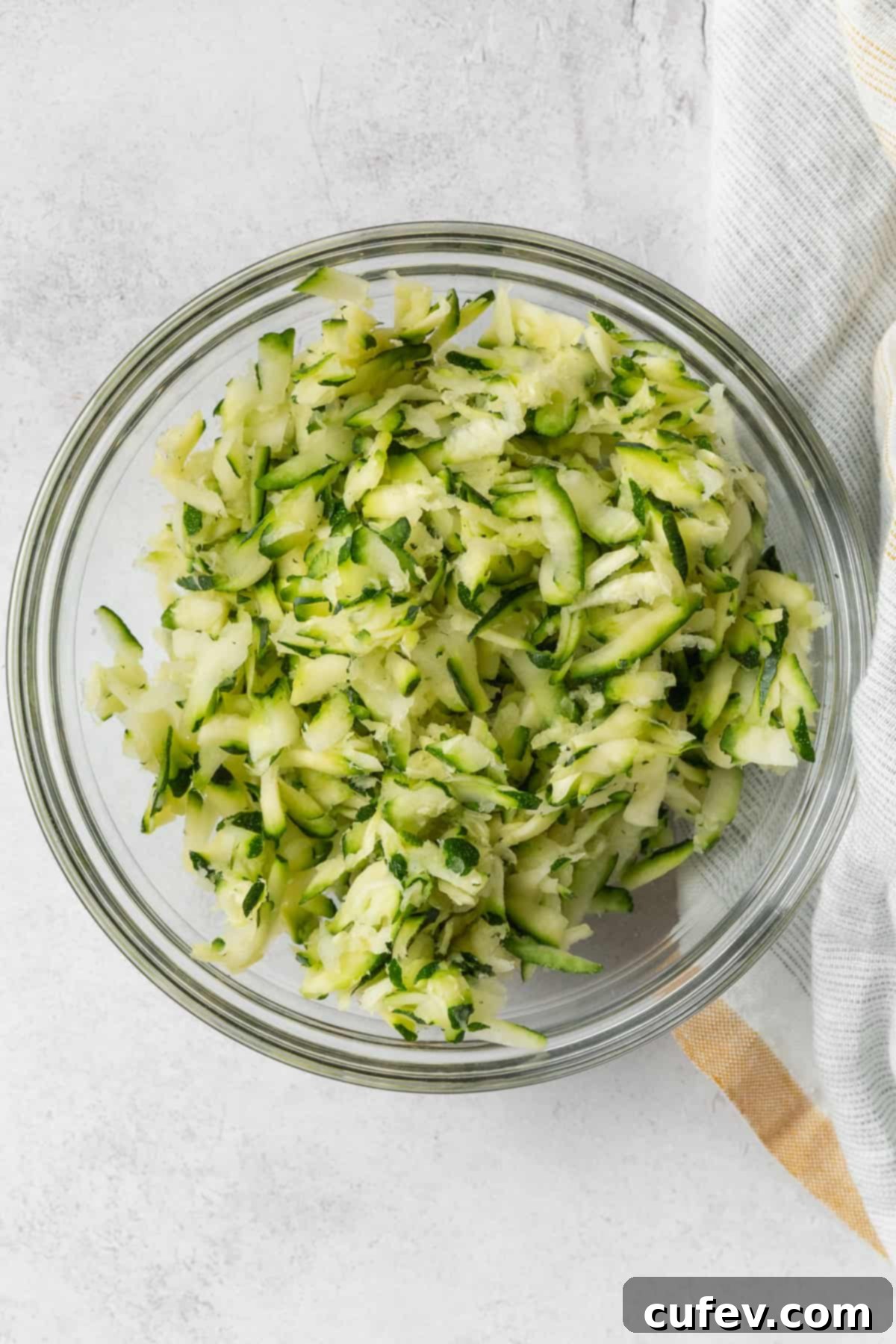 A glass bowl of grated zucchini.