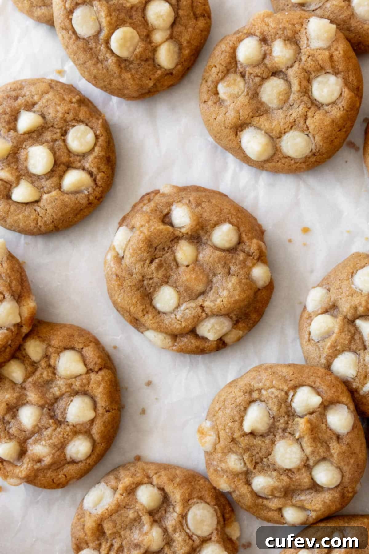 Gluten free pumpkin cookies with white chocolate chips on a piece of parchment paper.