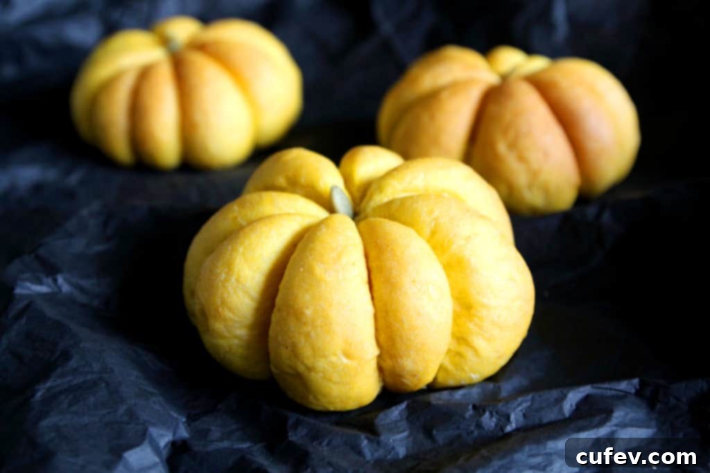Fluffy homemade pumpkin buns, ready to be sliced and filled for savory vegetarian sandwiches, perfect for fall and Halloween.