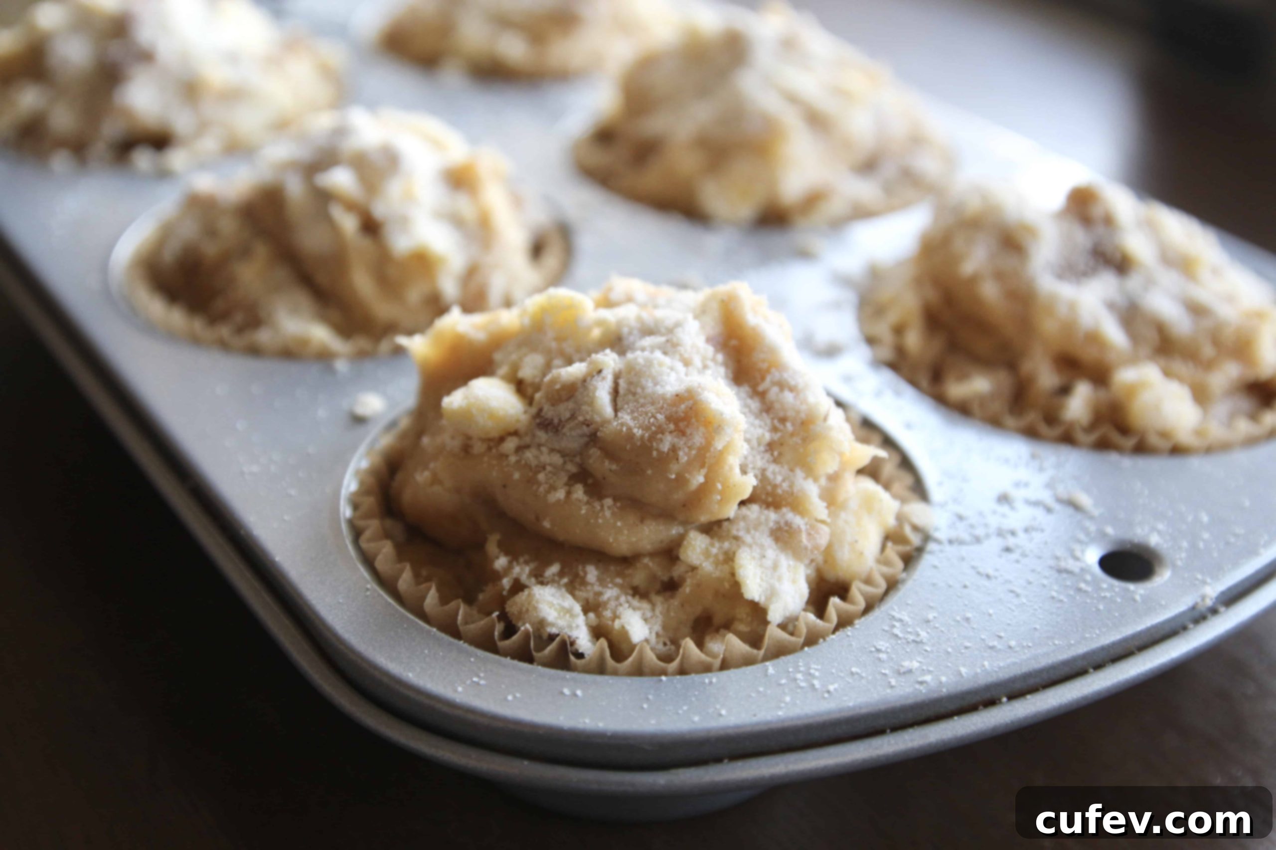 Apple muffin batter in a muffin tin