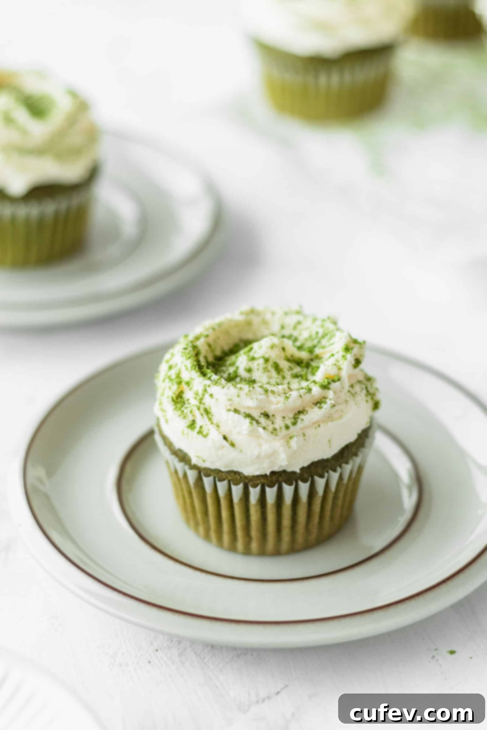 Matcha cupcake on a plate with silky white chocolate frosting