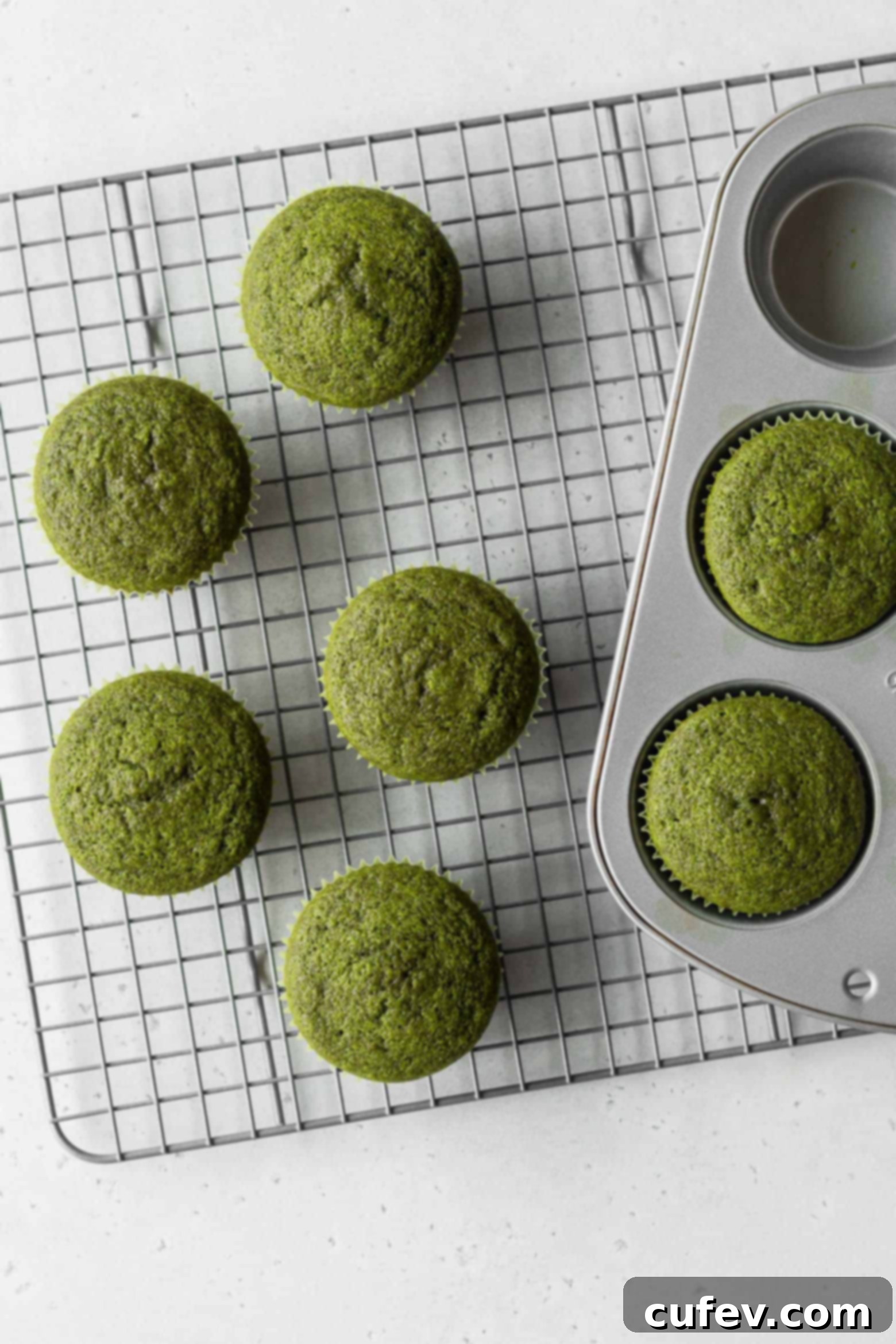 Freshly baked matcha cupcakes cooling on a wire rack