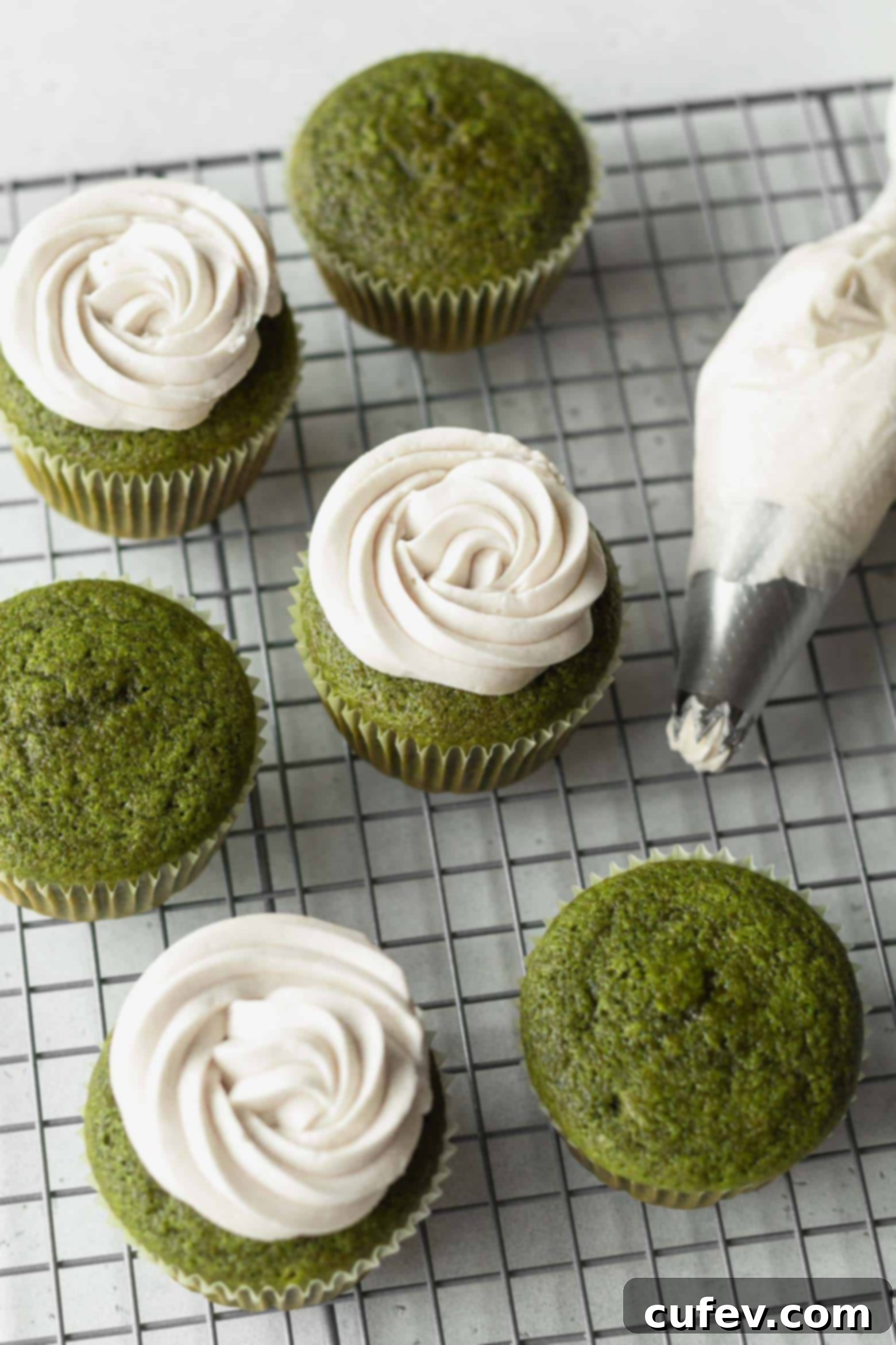 White chocolate frosting beautifully piped on matcha green tea cupcakes