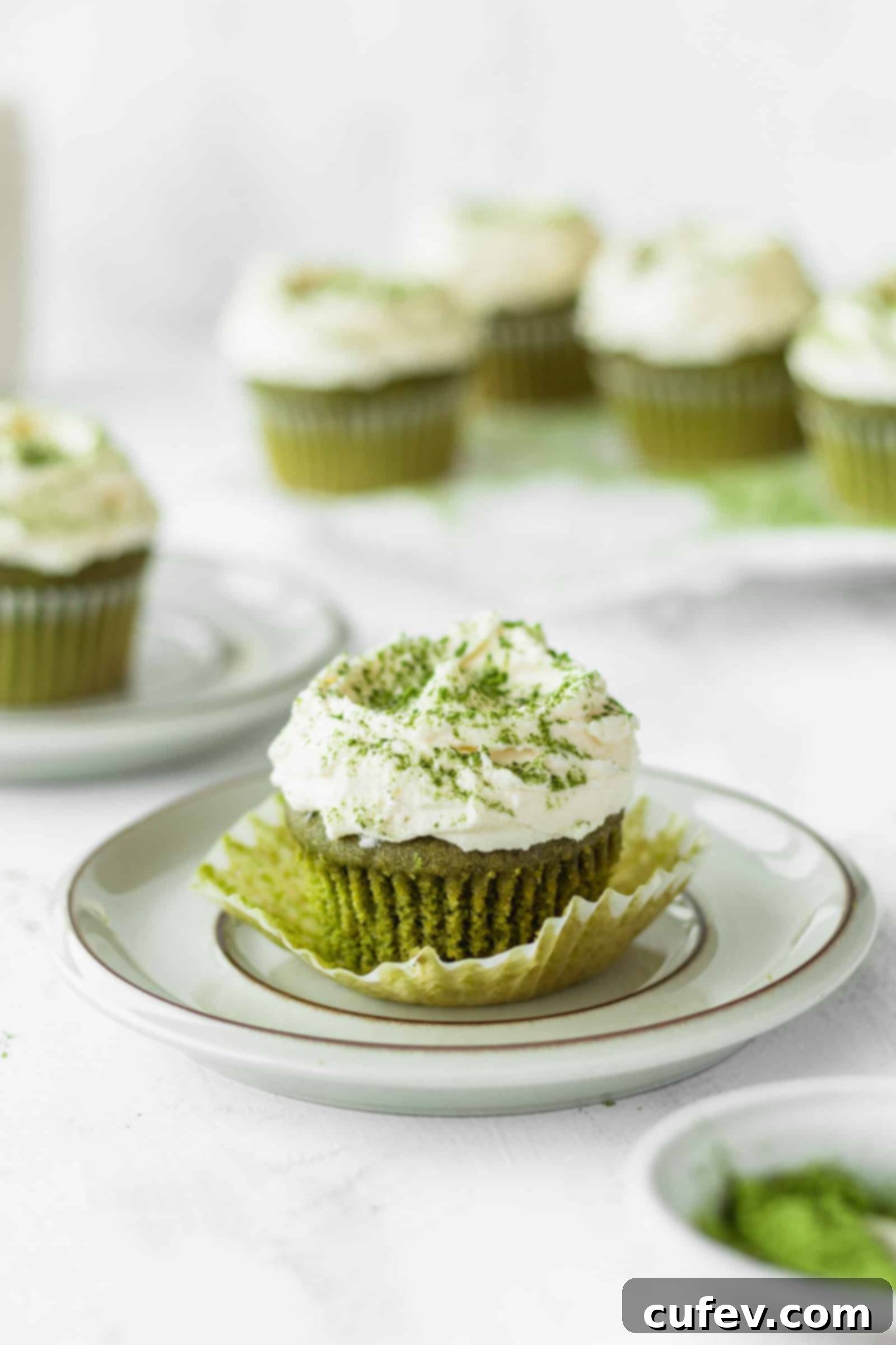 Green tea cupcake being unwrapped from plastic wrap on a plate