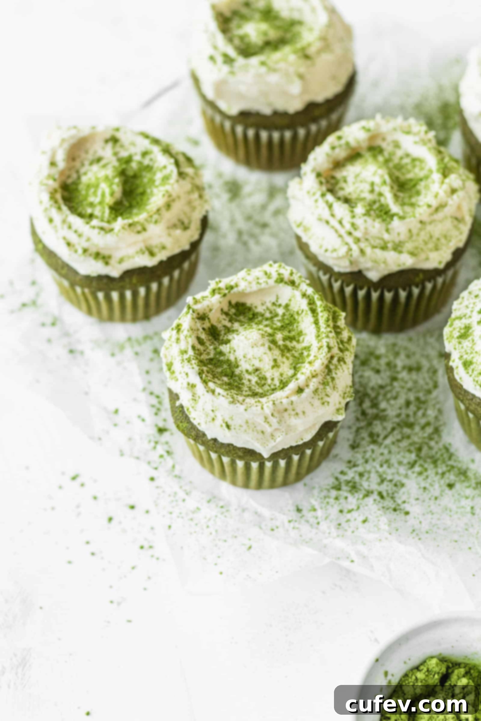 Fluffy white chocolate frosting on matcha green tea cupcakes close up
