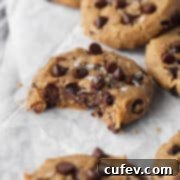 A close-up of a perfectly baked chocolate chip chickpea cookie, golden brown and inviting.