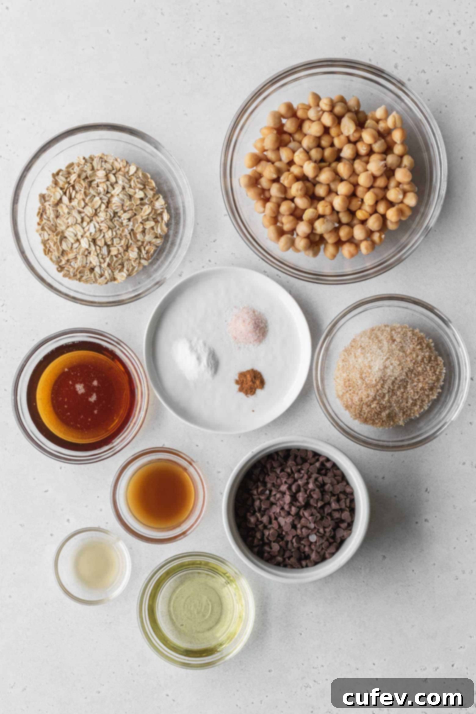 All the measured ingredients for chocolate chip chickpea cookies laid out in individual bowls.