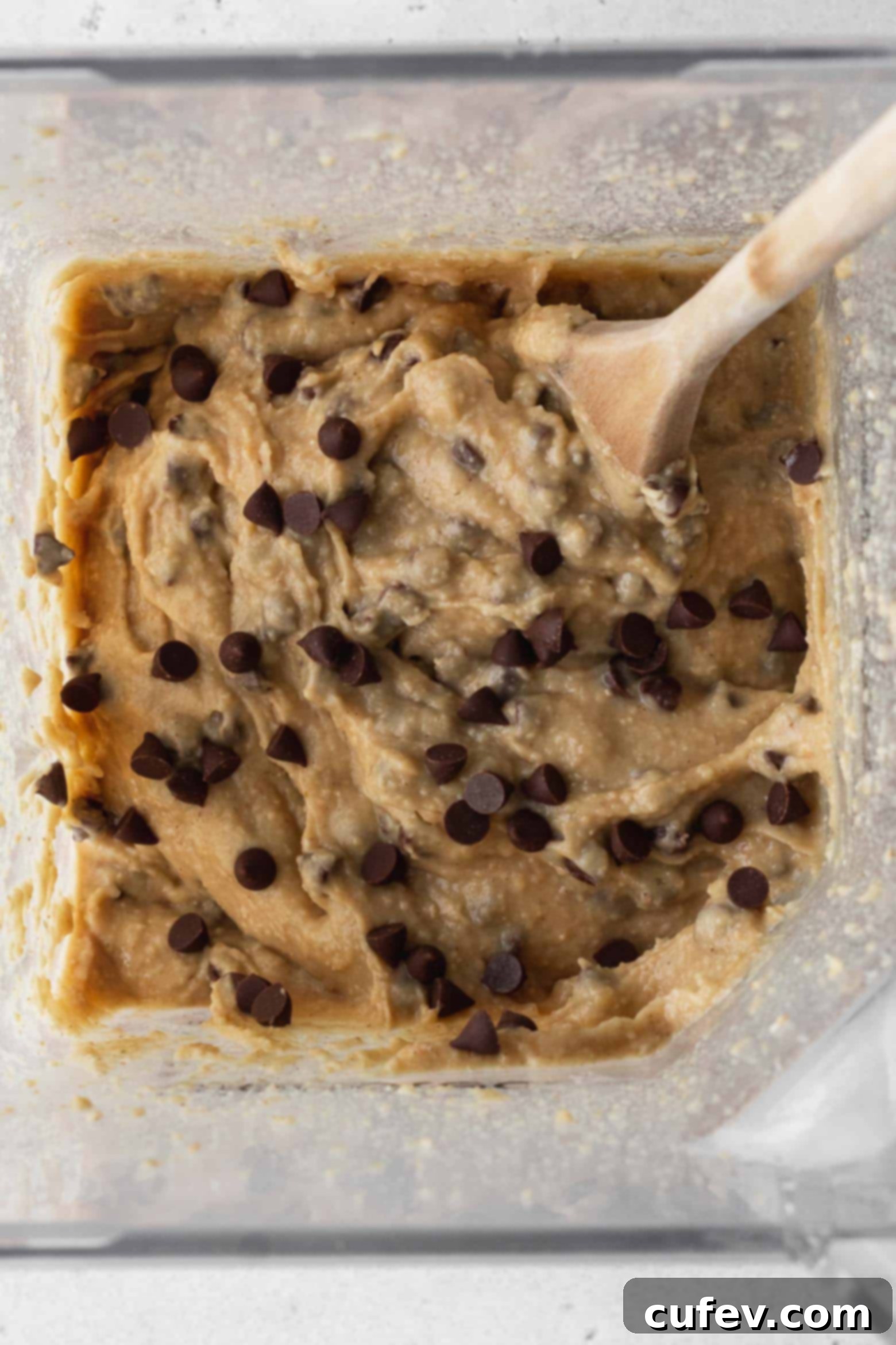 Chickpea cookie dough with chocolate chips stirred in, ready for baking.