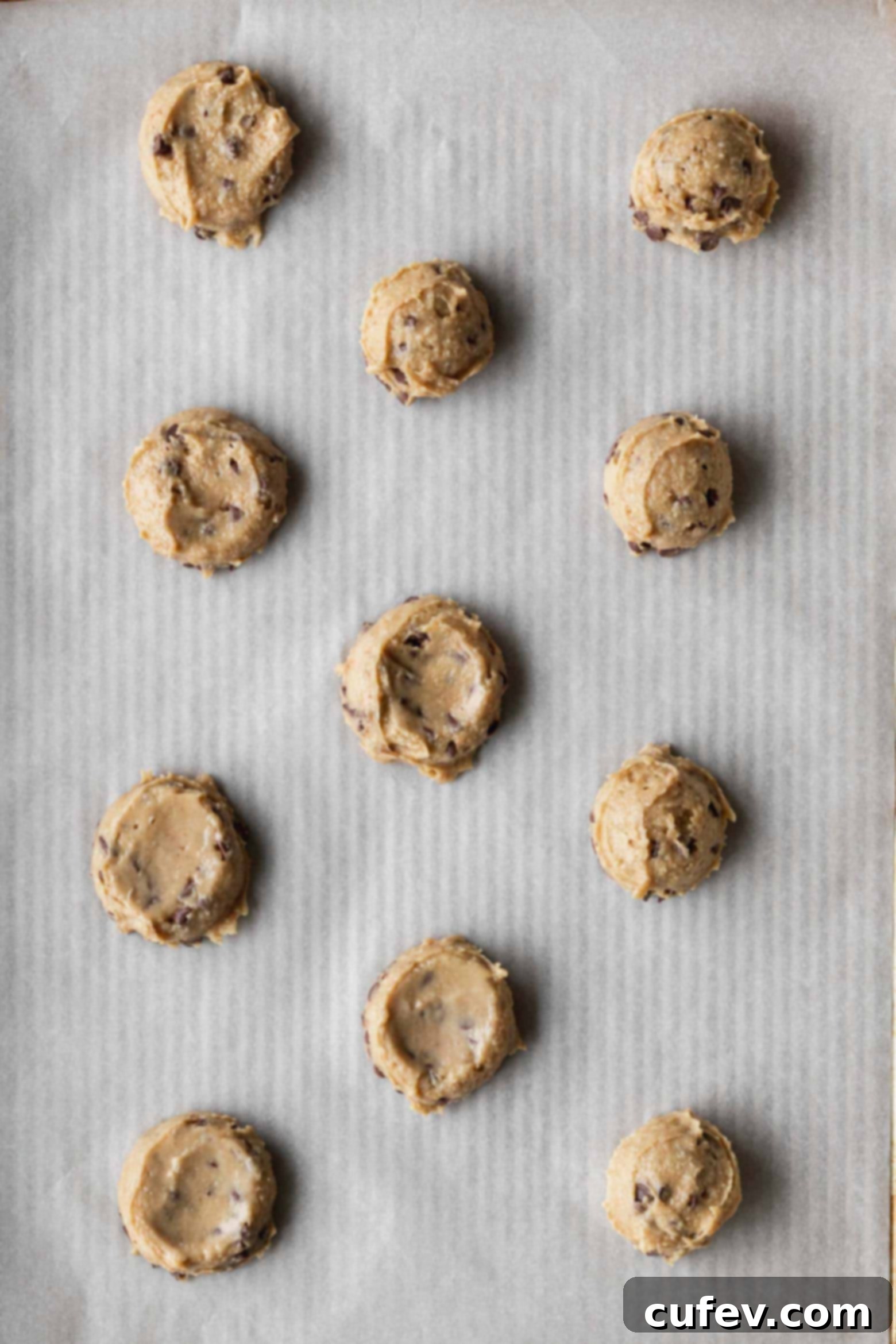 Rounded portions of chickpea cookie dough placed on a baking sheet.