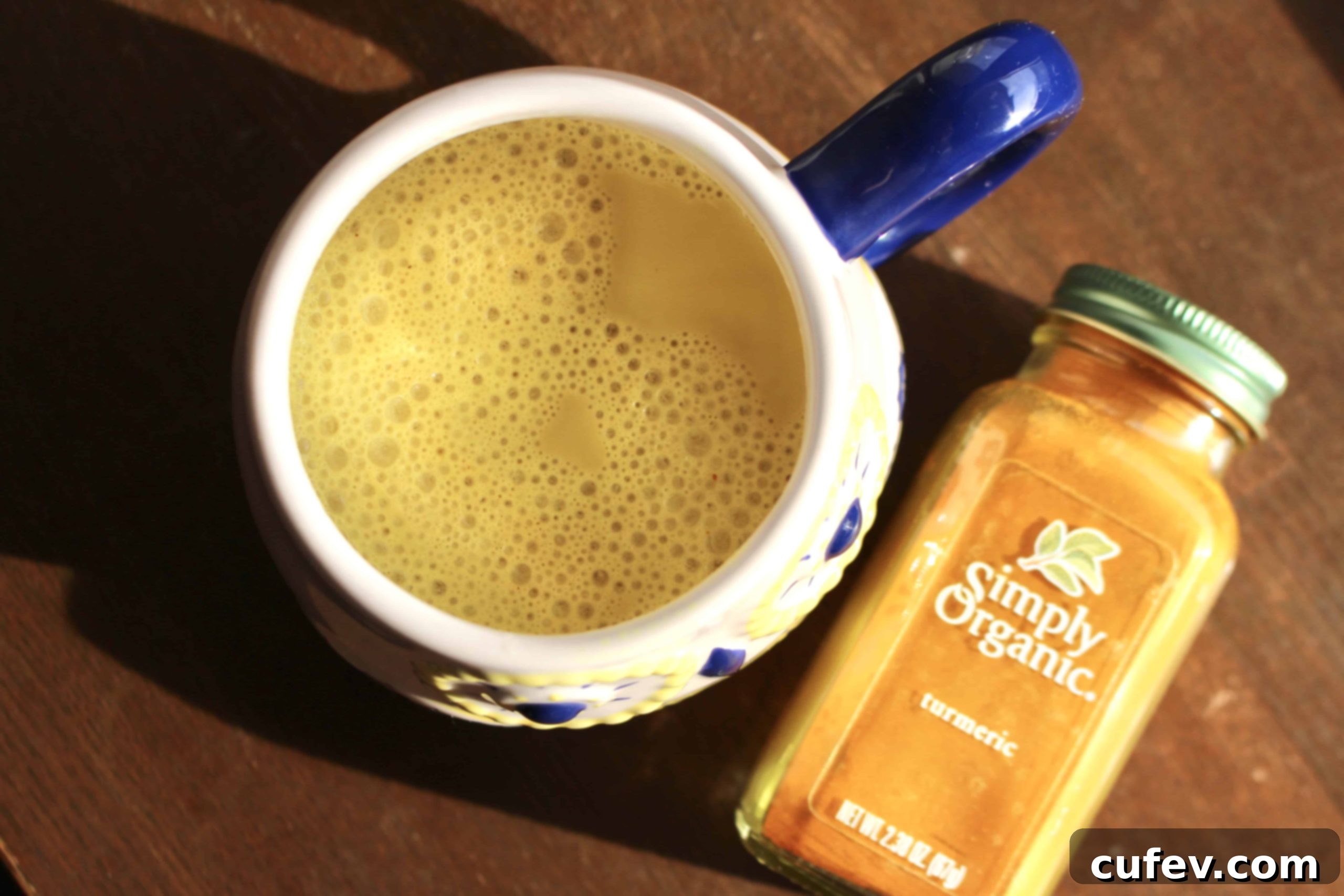 Golden Milk in a mug next to a jar of ground turmeric.