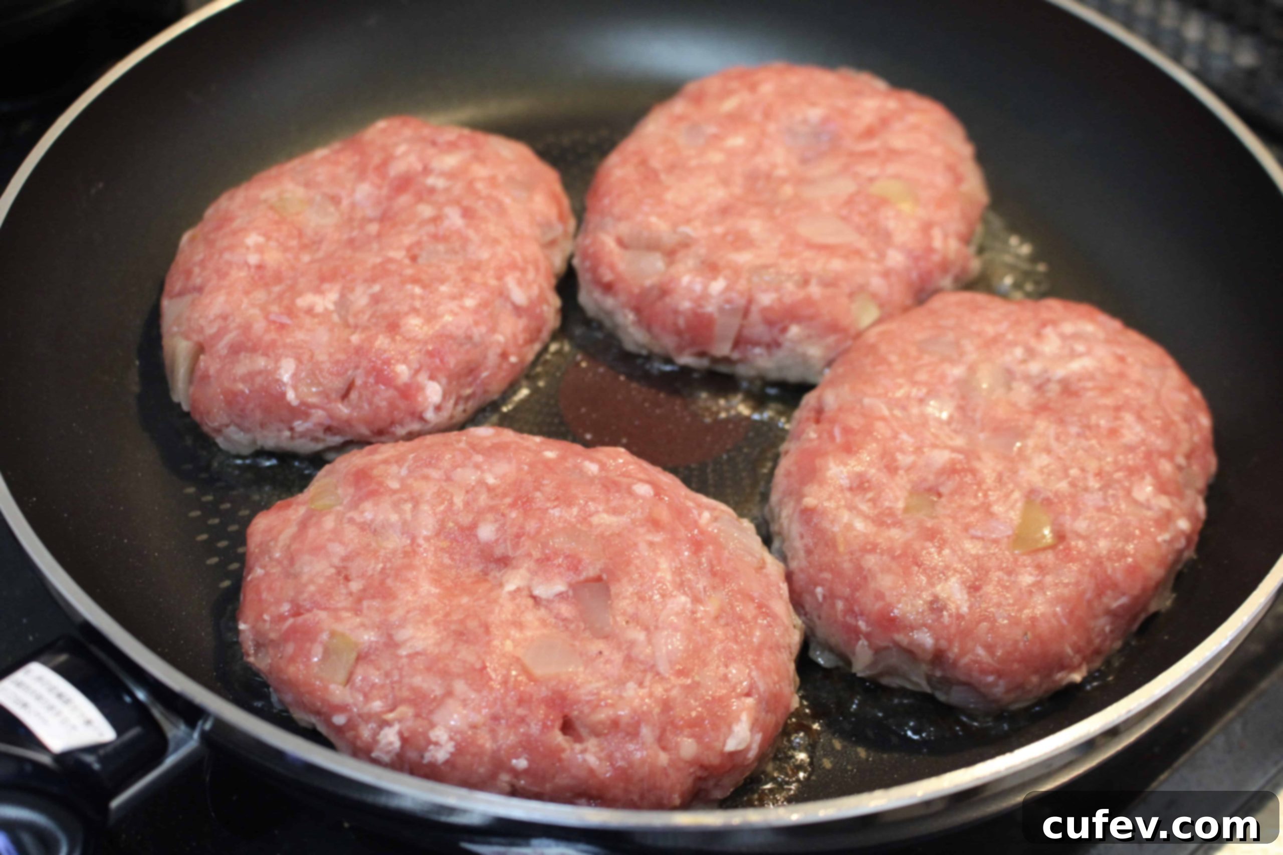 Four raw Salisbury steak patties with a small indentation in the center, ready for cooking
