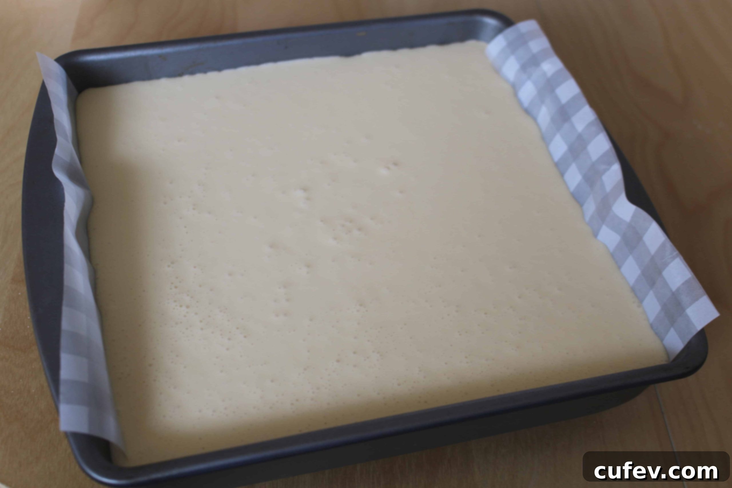 Pressing the biscuit crumb crust into a square pan