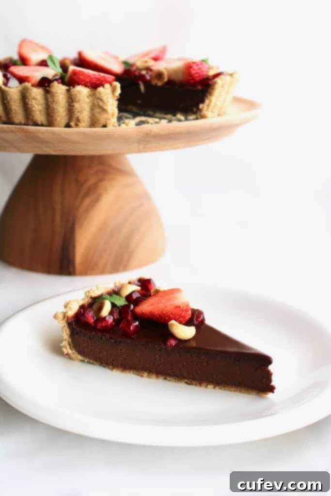 Velvet Bailey's Chocolate Delight 6 Close-up of the glossy ganache topping on the Bailey's chocolate tart, with fruit reflections and a sprinkle of hazelnuts.