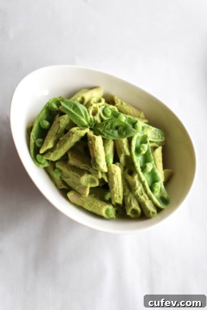 Vibrant green vegan mac and cheese pasta dish, naturally colored with wholesome vegetables and herbs.