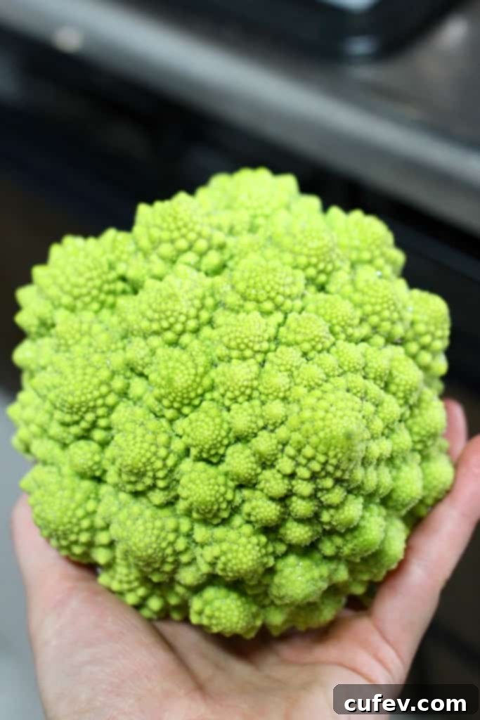 Close-up of romanesco broccoli florets, showcasing its intricate fractal patterns and light green hue.