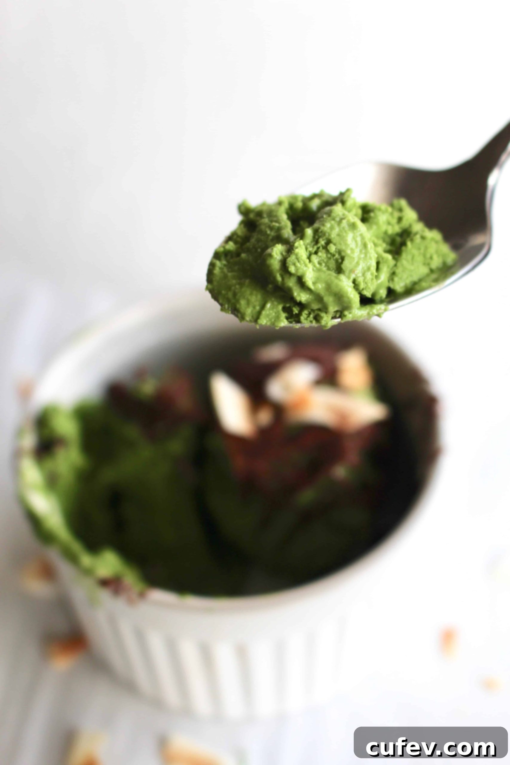A spoon scooping a bite of dairy-free matcha ice cream, showing its smooth texture.