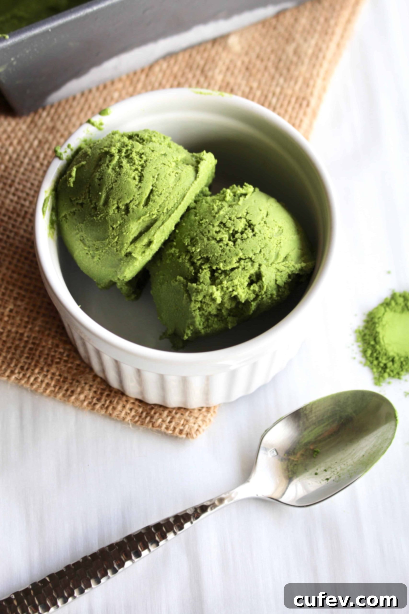 Vegan Matcha Ice Cream scoops in a white dish, garnished with toppings.