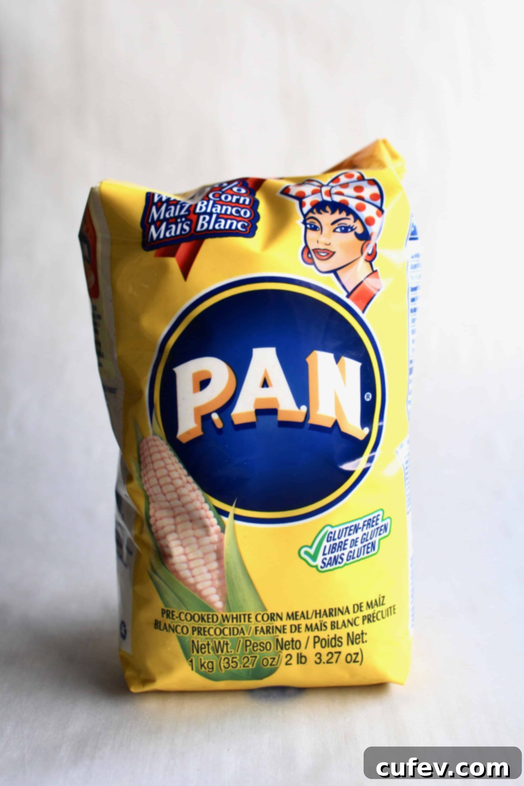 A vibrant yellow bag of Harina P.A.N. brand pre-cooked cornmeal sits against a clean white background, highlighting the key ingredient for authentic arepas.