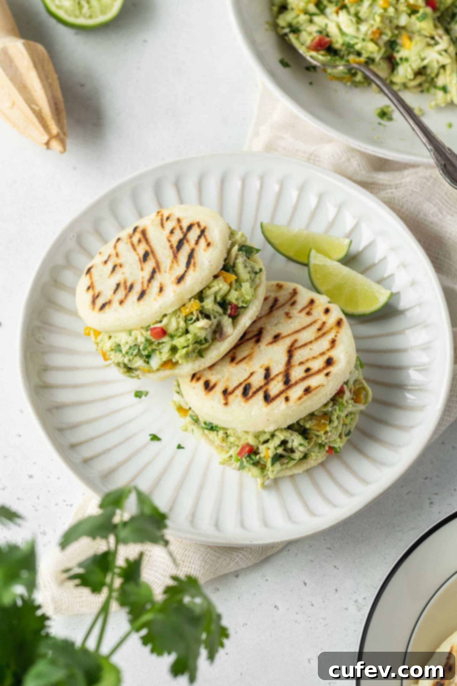 Two reina pepiada on a plate with lime wedges