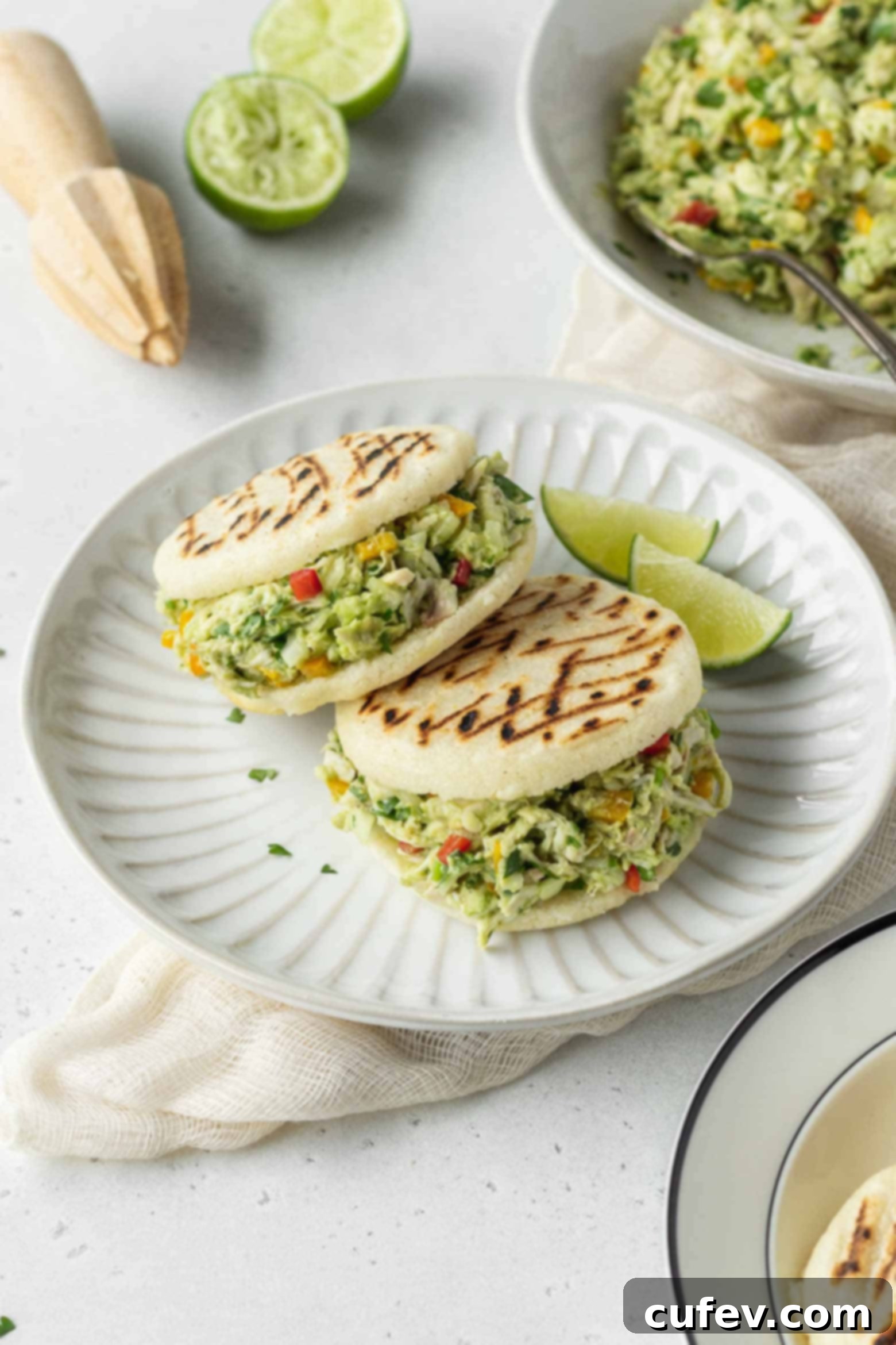Two reina pepiada arepas on a plate