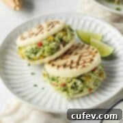 Two reina pepiada arepas on a plate