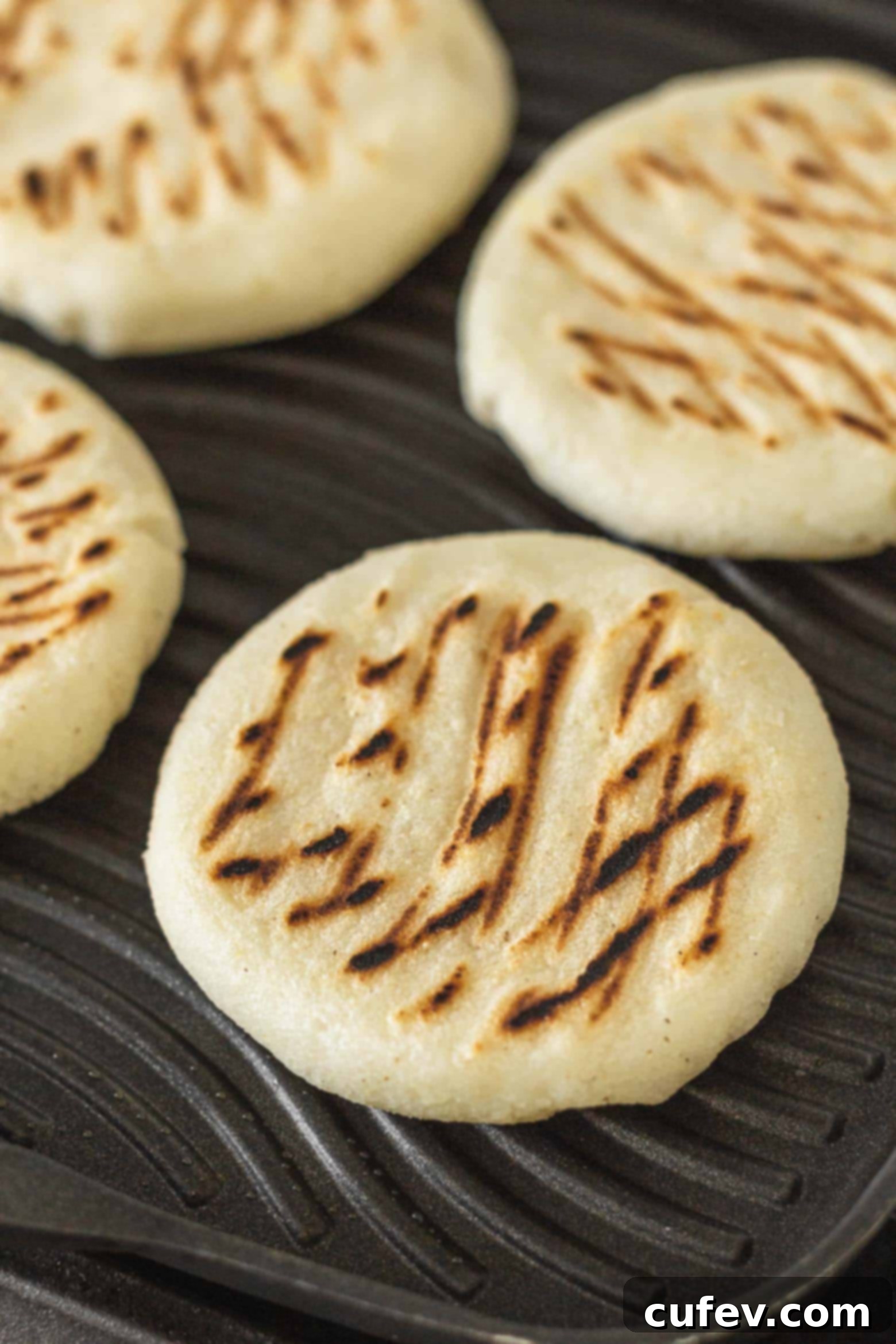 Arepas cooking on a grill