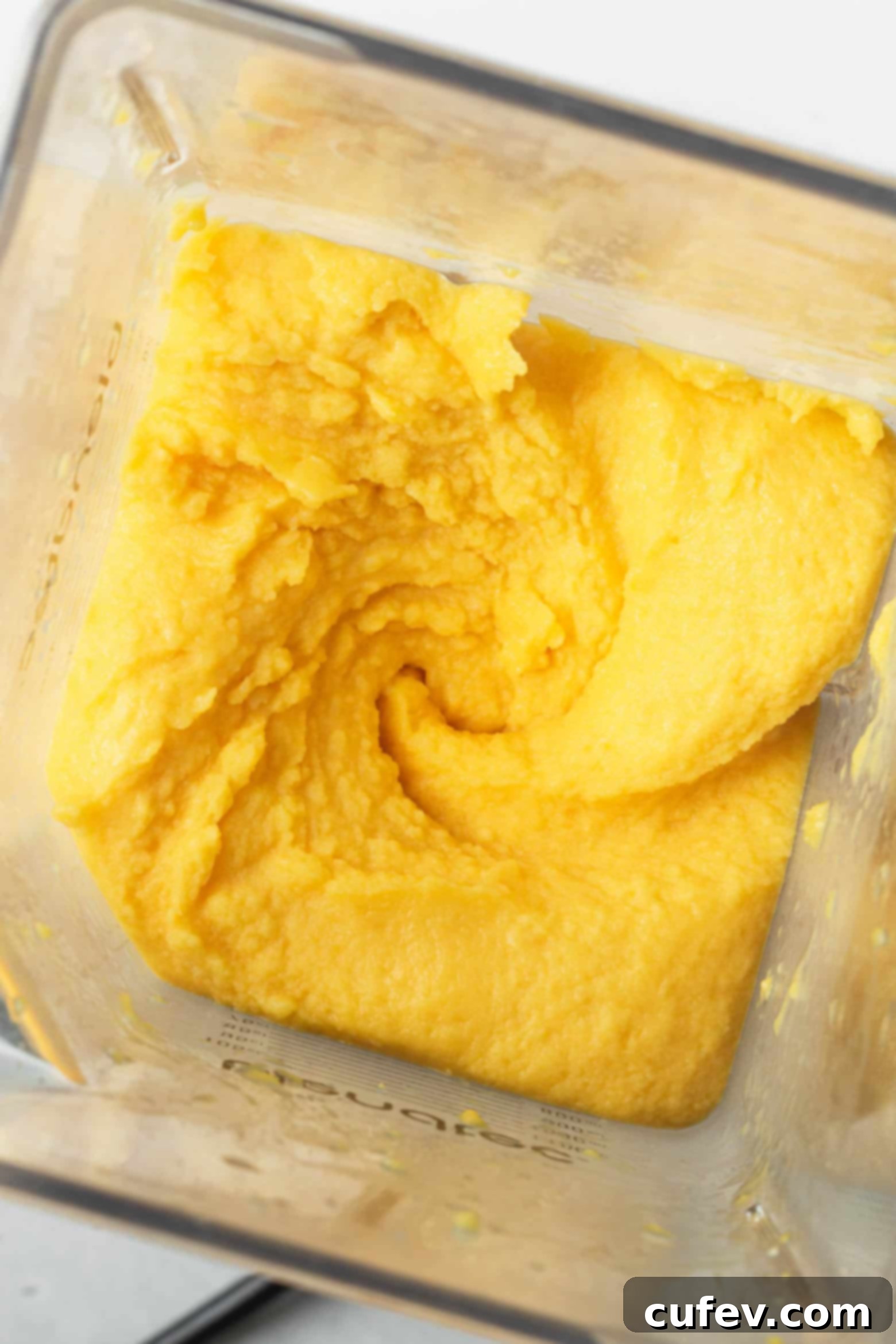 Two Ingredient Mango Sorbet 5 Blended mango sorbet in a food processor, showing its creamy, smooth consistency