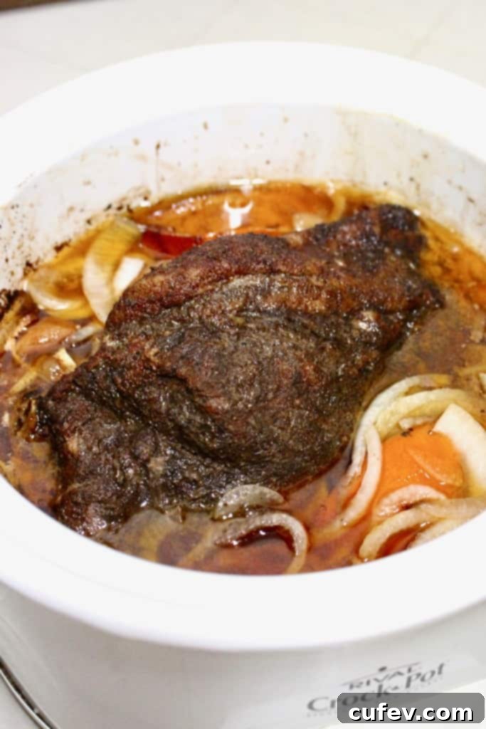 Carnitas cooking in a crock pot.