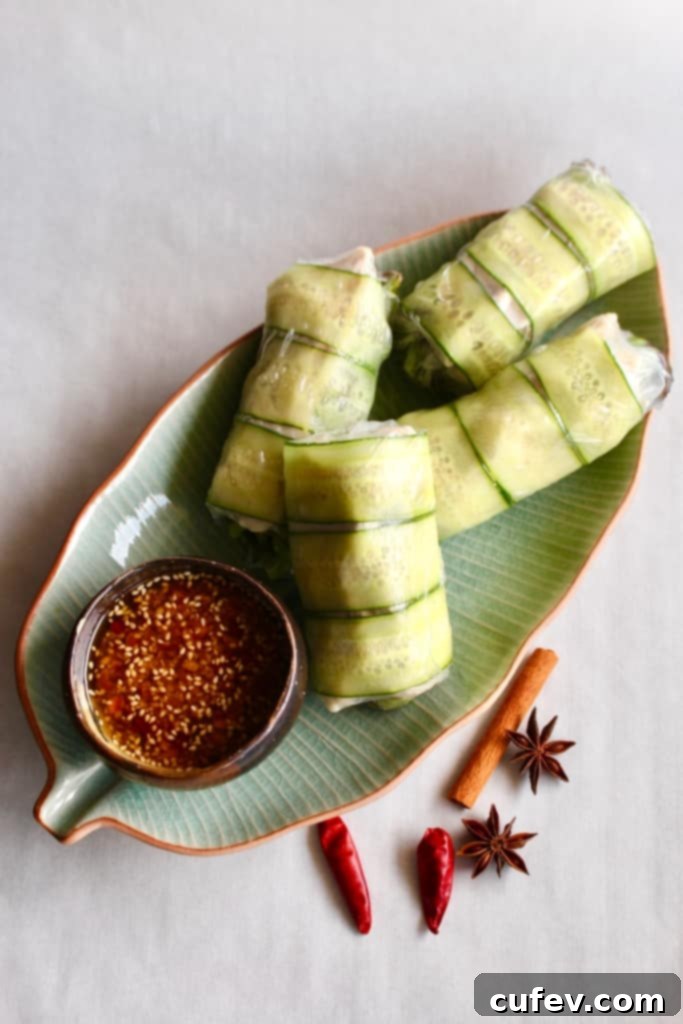 Summer rolls on a leaf-shaped dish with spices scattered next to it.