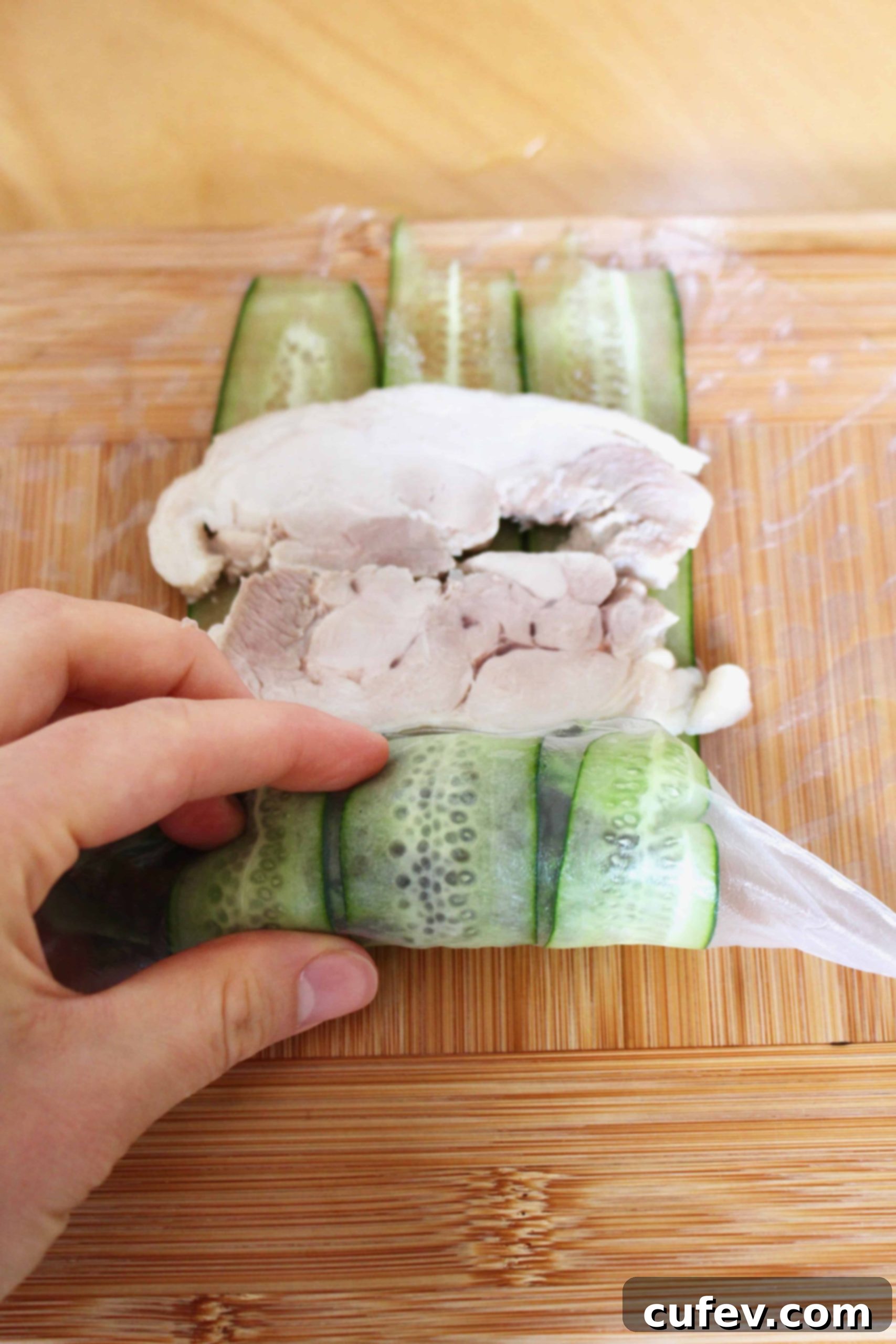 A hand rolling the summer rolls.