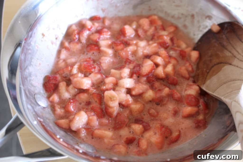 Chopped fresh strawberries, sugar, cinnamon, and cornstarch simmering in a pan to create the roll filling.