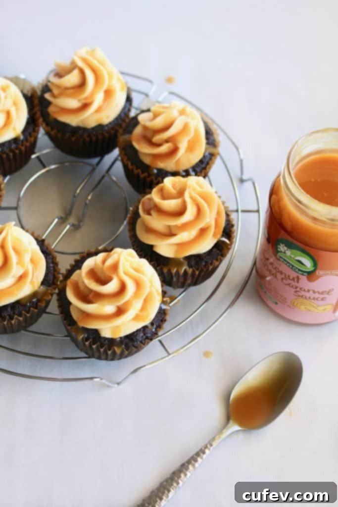 Close-up of a vegan salted caramel chocolate cupcake, showcasing the moist chocolate cake, rich caramel filling, and silky buttercream, ready for a delicious bite.