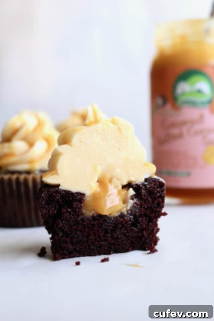 Close-up of a vegan salted caramel chocolate cupcake, split open to reveal the luscious caramel oozing from the moist chocolate cake, a truly indulgent sight.
