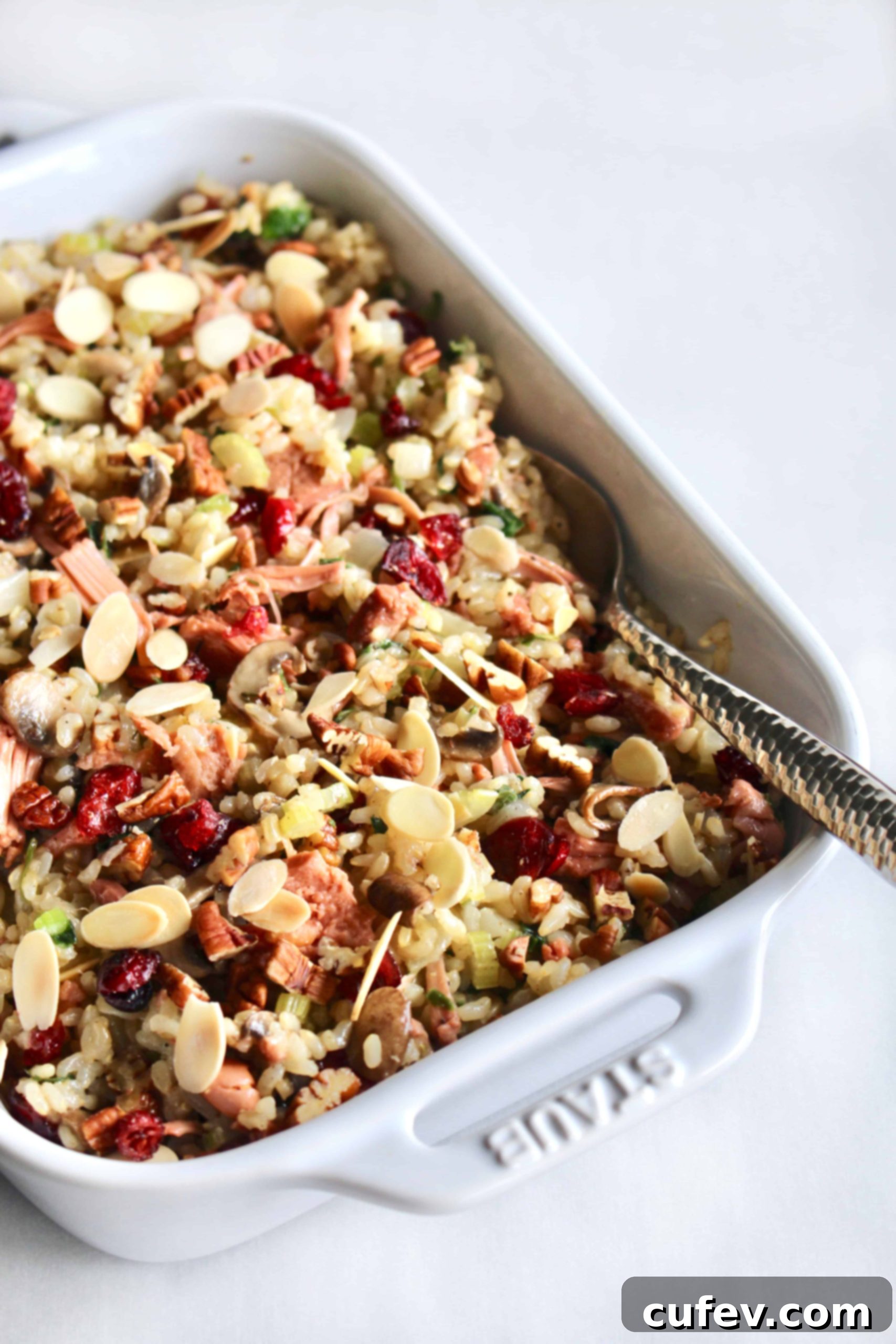 A beautifully presented vegan and gluten-free brown rice stuffing with jackfruit, cranberries, and nuts in a festive serving dish, ideal for holiday gatherings.