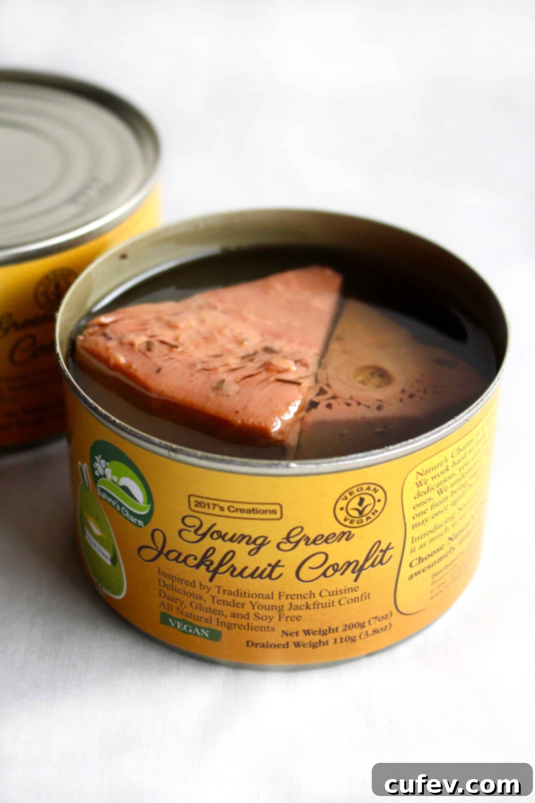 Two cans of Nature's Charm young green jackfruit confit, highlighting its suitability as an excellent vegan meat substitute for various recipes.