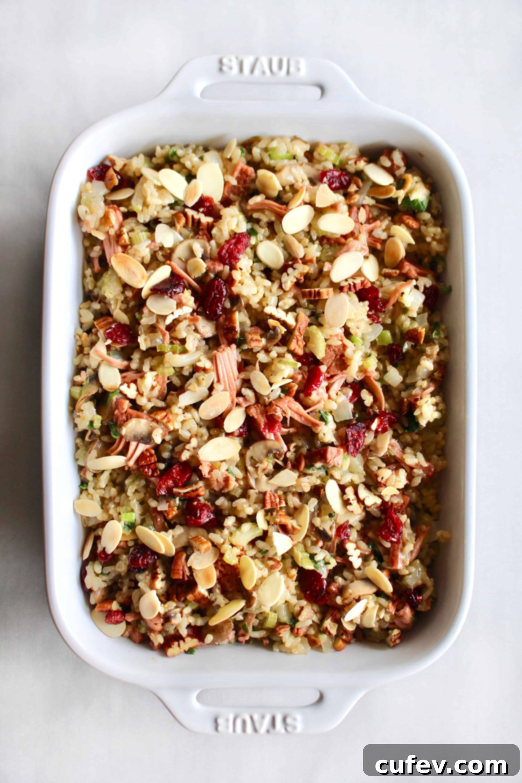 Cooking vegan rice stuffing on the stovetop, with a pot of fluffy brown rice and a skillet of sautéed vegetables and jackfruit, demonstrating the ease of preparation.