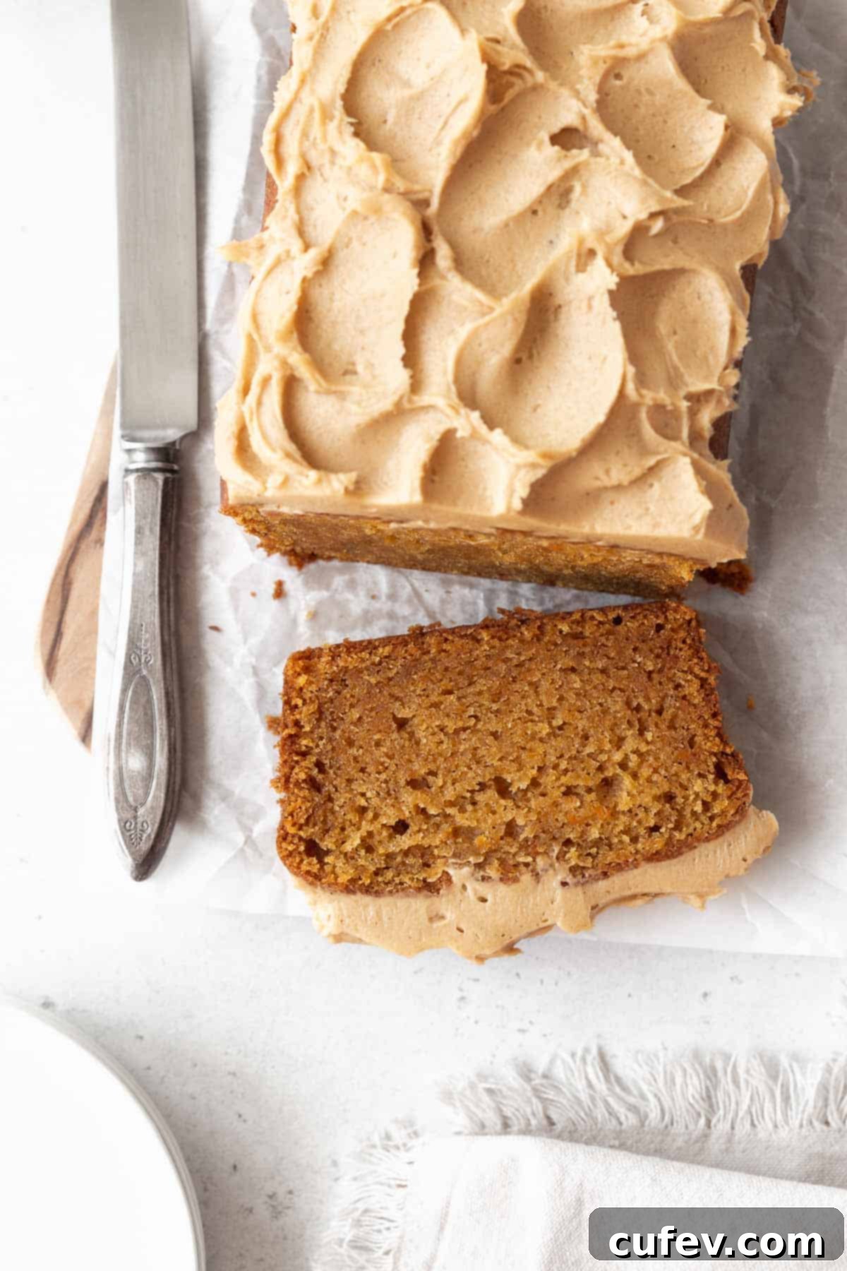 An overhead shot of a delightful sweet potato cake, with a generous slice already removed, showcasing its fluffy texture and inviting color.
