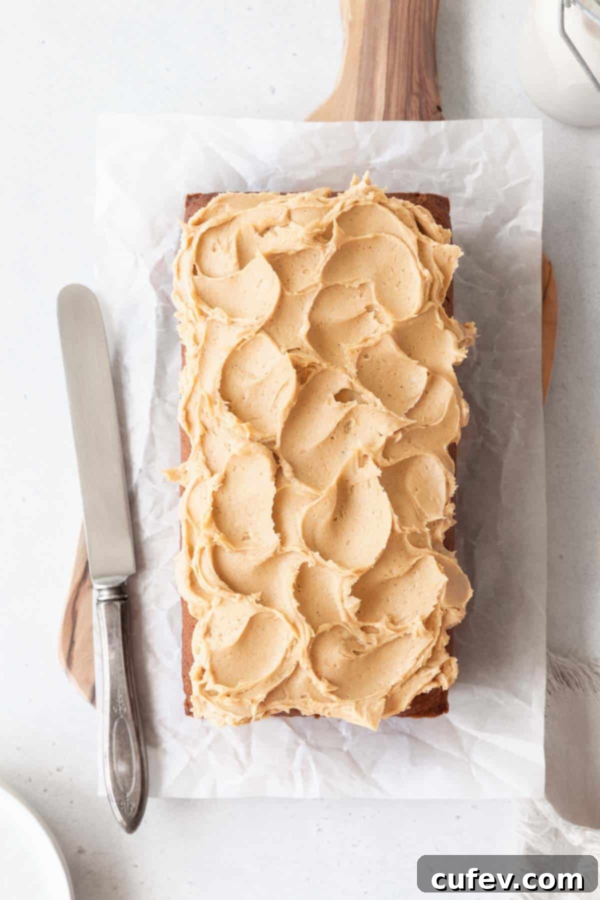 A beautifully frosted loaf of sweet potato cake, topped with smooth and creamy maple cashew frosting, ready to be served.