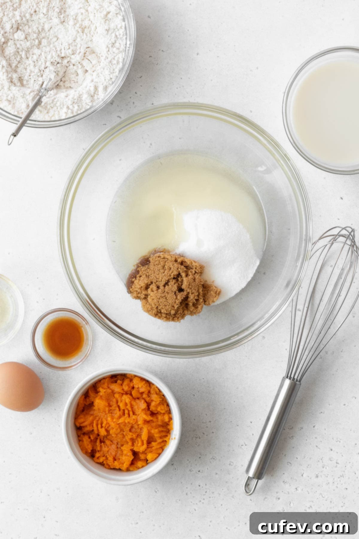 A large glass bowl holding the initial wet ingredients: oil, granulated sugar, and brown sugar, perfectly blended.