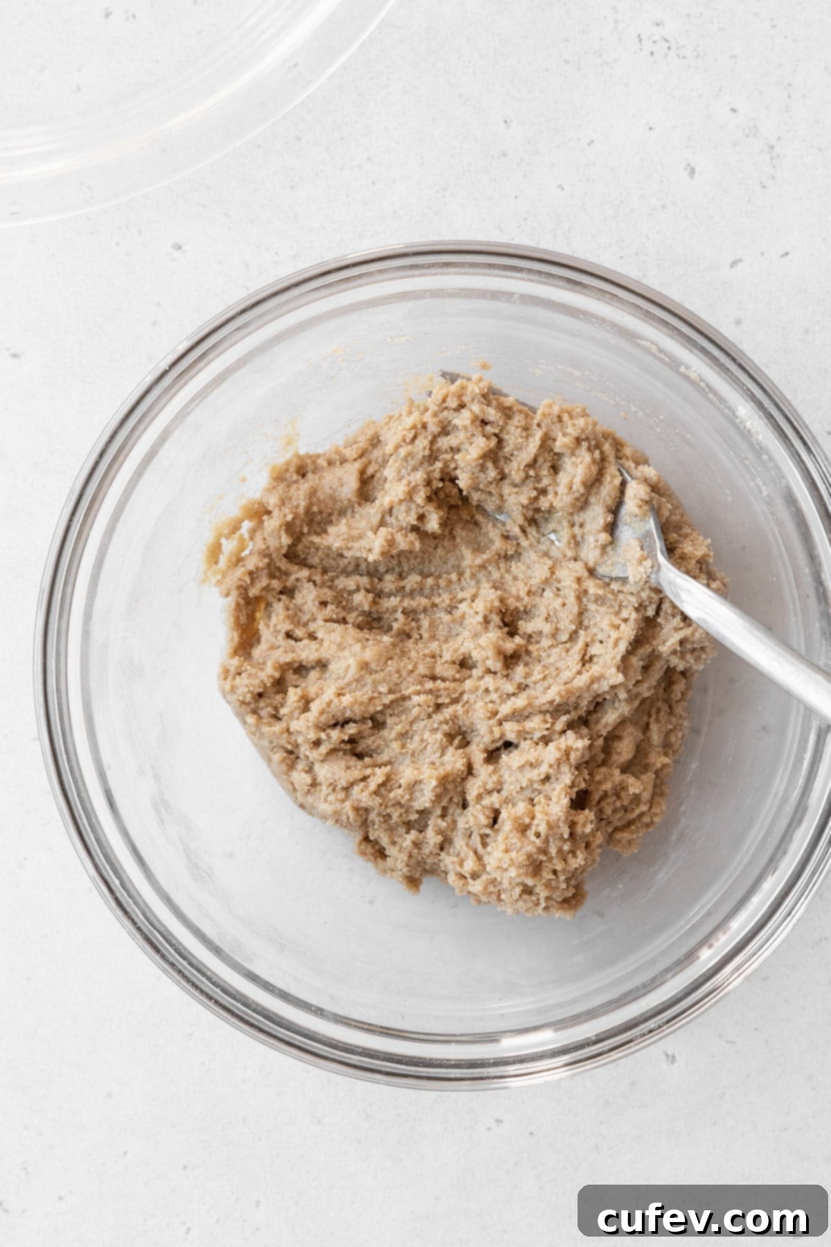 The perfectly crumbly oat pie crust dough resting in a clear glass bowl, ready to be pressed.