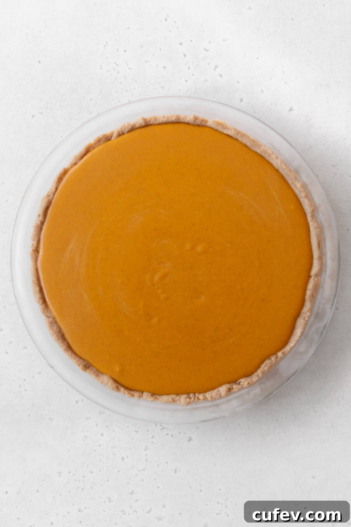 The unbaked eggless pumpkin pie, filled with its creamy custard, ready to go into the oven.
