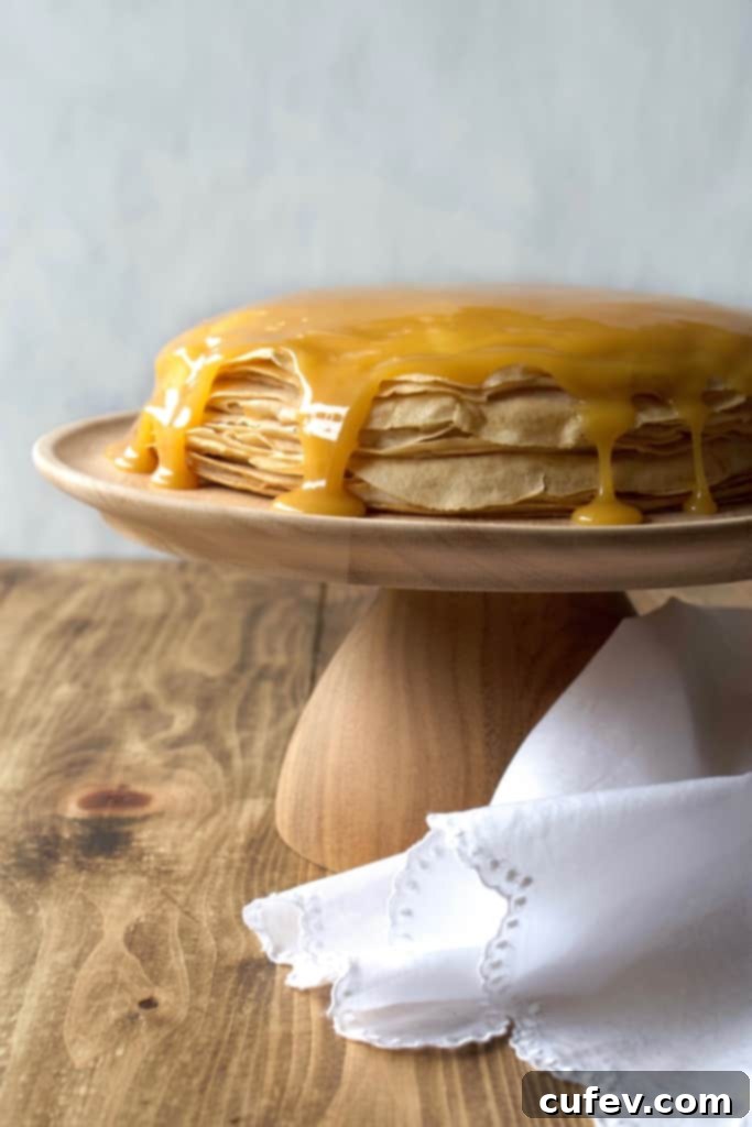 Close-up of a perfectly cooked vegan crepe with a light golden hue, showcasing its delicate and thin texture, ready to be layered into the cake.