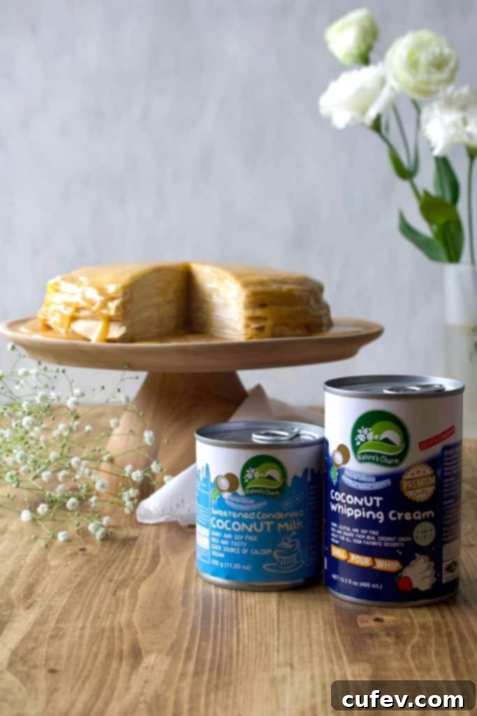 The finished vegan mille crêpe cake, elegantly sliced to reveal the many thin layers of crepes and creamy coconut whipped cream, crowned with homemade dulce de leche.