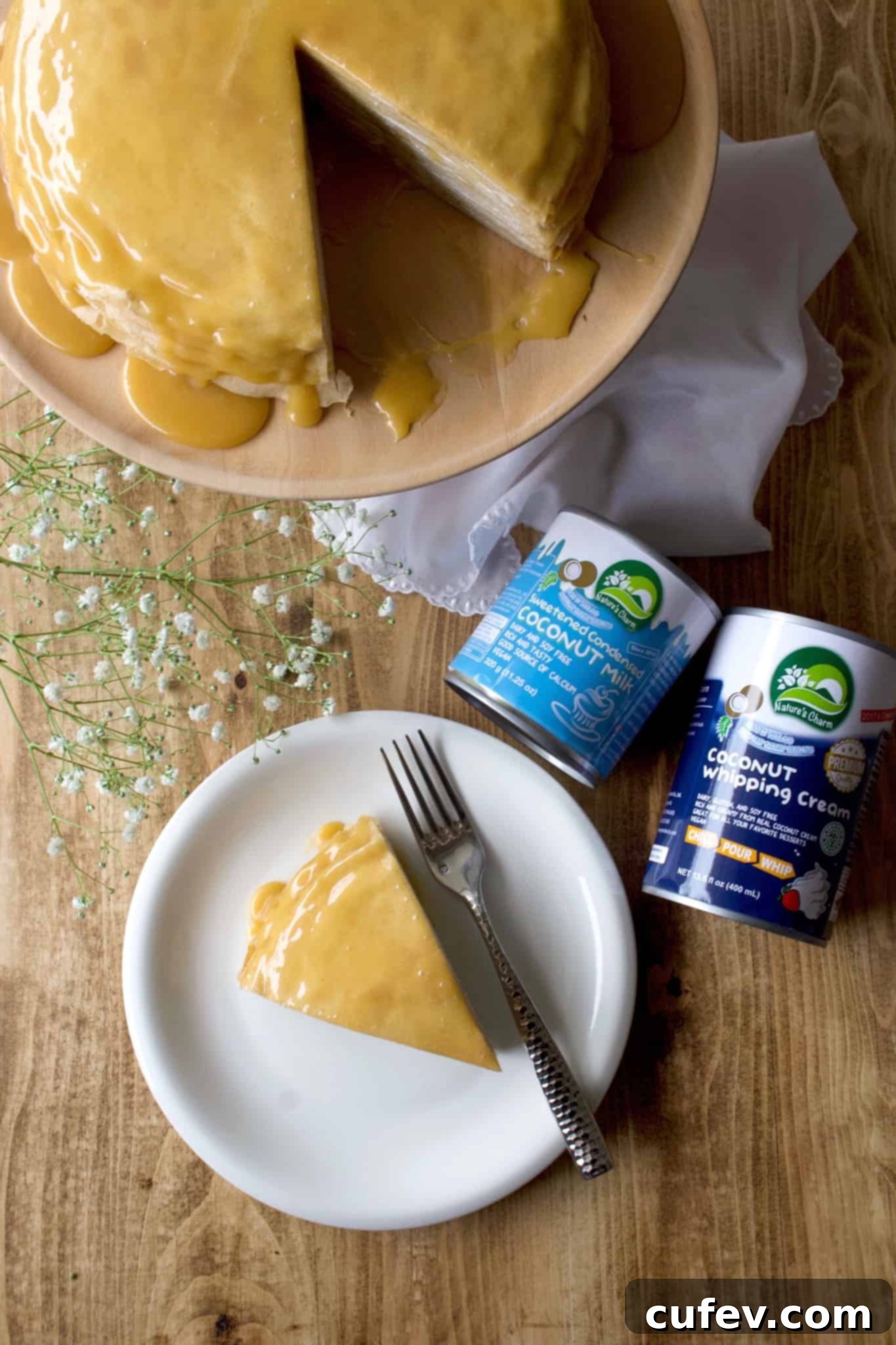 A beautifully cut slice of vegan mille crêpe cake, displaying perfectly stacked layers of crepes, coconut whipped cream, and a luscious dulce de leche topping.